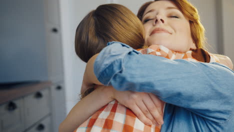 good looking young mother hugging her little daughter tight. rear of the girl. portrait. close up. indoor