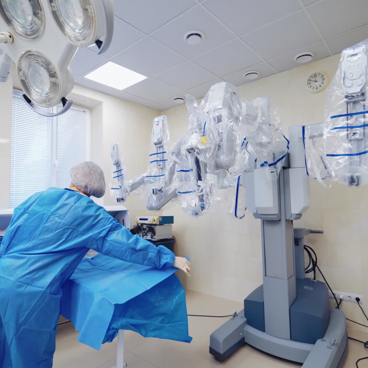 Robotic equipment in surgery room. Nurse works in a modern operating room. Medical robot in clinic. Hi-tech equipment in the hospital.