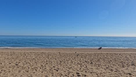 Playa-De-Arena-Con-Un-Pescador,-Vista-Amplia