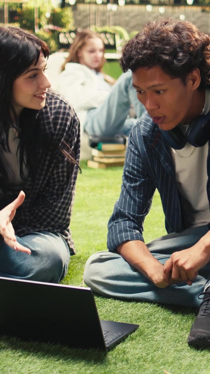Vertical Video Students in project discussion sitting on grass and sharing ideas