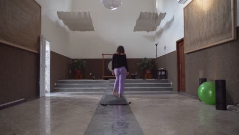 girl do yoga in the meditation hall with a big gong