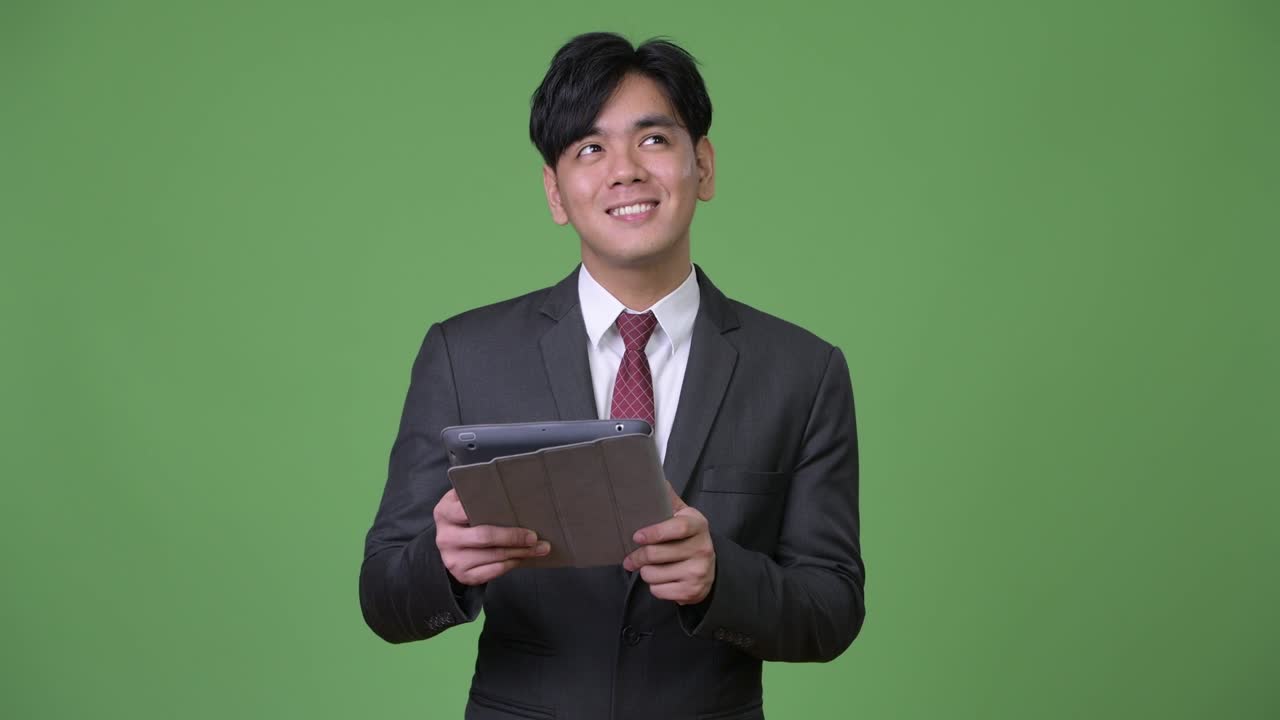 joven empresario asiático guapo usando una tableta digital