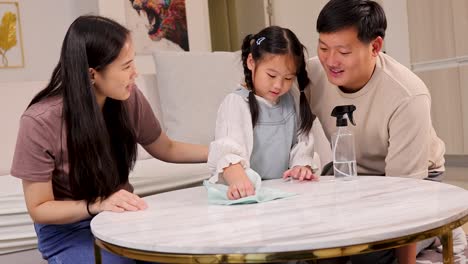a family joyfully cleans a table together, highlighting teamwork and bonding in a warm, well-lit home environment