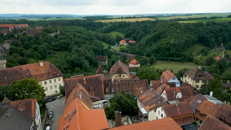 4k aerial drone video of the ancient catholic church and double bridge along the tauber river in rothenburg, germany