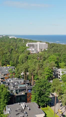 Drone view of luxury residential area in Jurmala with coastline in background, vertical
