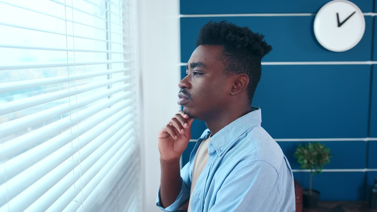 joven pensativo hombre de negocios afroamericano empresario mirando por la ventana