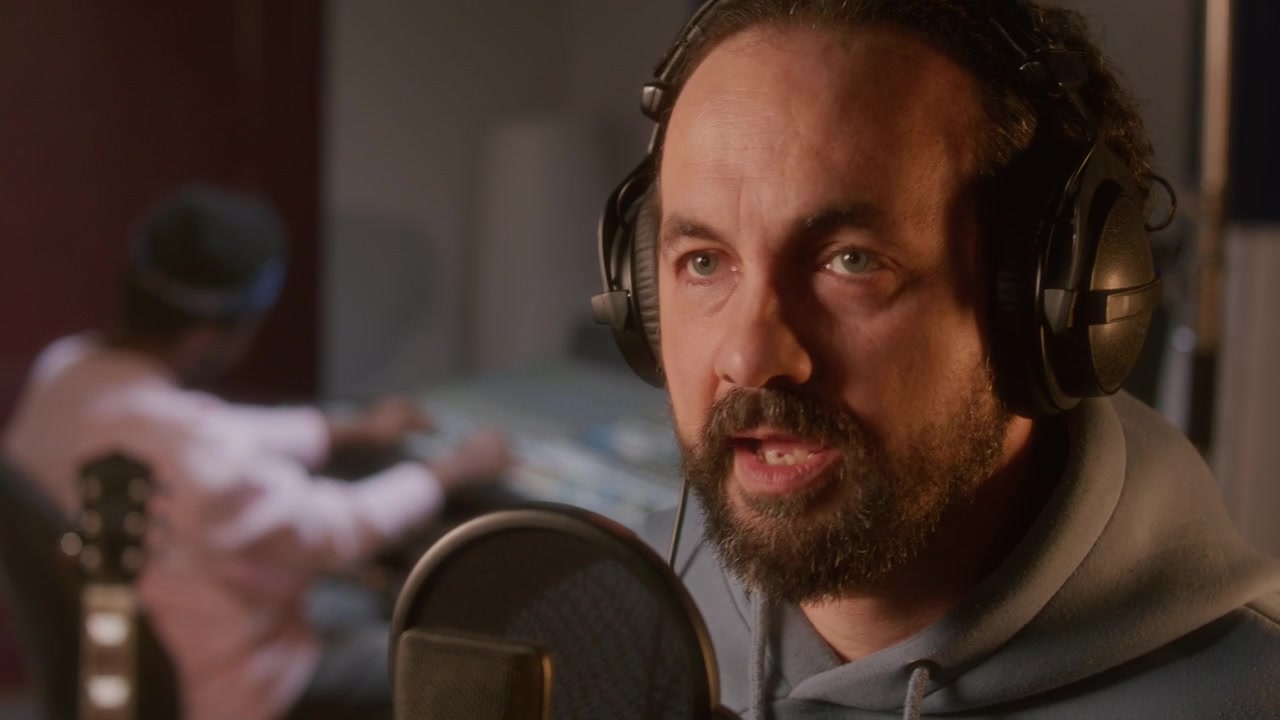 Nærbilde av profesjonell mannlig sanger som spiller inn vokal i musikkstudio