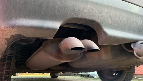 handheld closeup: smoke coming from old diesel audi car exhaust pipe