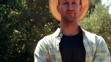 smiling man standing with arms crossed in olive farm