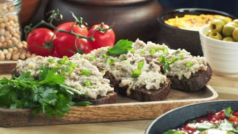 israeli cuisine. forshmak on black rye bread decorated with parsley close-up. national jewish herring dish, middle eastern culture. traditional snack vorschmack made of fish fillet