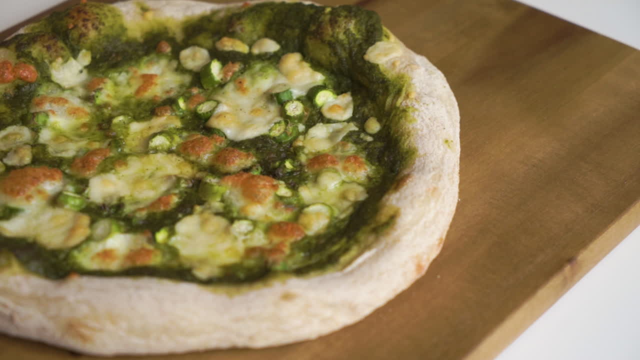 sartén a cámara lenta de derecha a izquierda de una deliciosa pizza vegetariana italiana casera con una corteza de masa fermentada lista para ser cortada y disfrutada por toda la familia