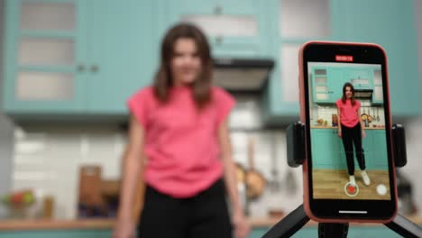 woman dancing in kitchen on smartphone