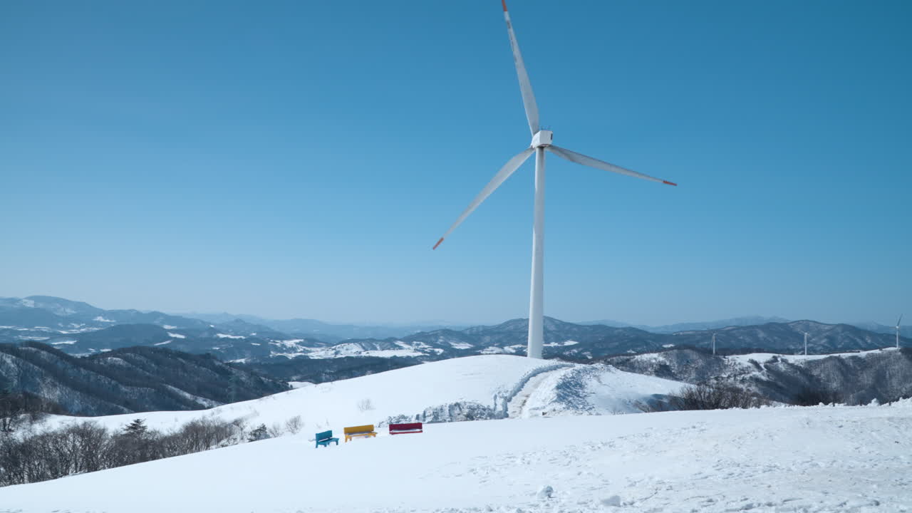 Massive Wind Turbine Rotates on Mountain Top in Winter Against Blue Sky at Daegwallyeong Sky Ranch, Daegwallyeong-myeon, Pyeongchang-gun, Gangwon-do, South Korea