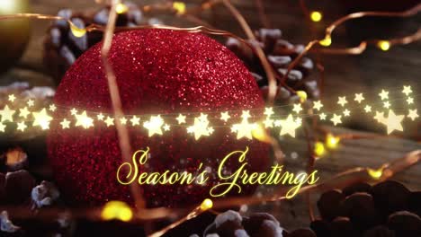 animation of seasons greetings text over christmas tree decorations