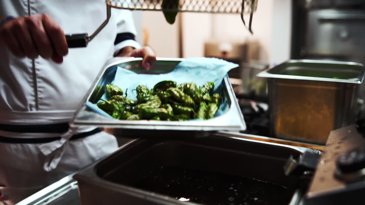 스페인산 피미엔토스 채소에서 여분의 기름을 걸러냅니다.