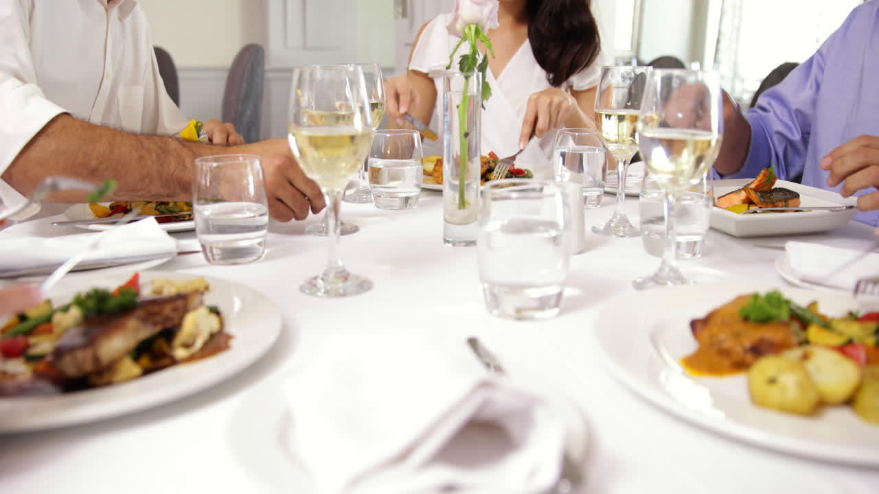 친구 들 의 그룹 이 함께 저녁 식사 를 하고 와인 을 마시며 건배 하고 있다