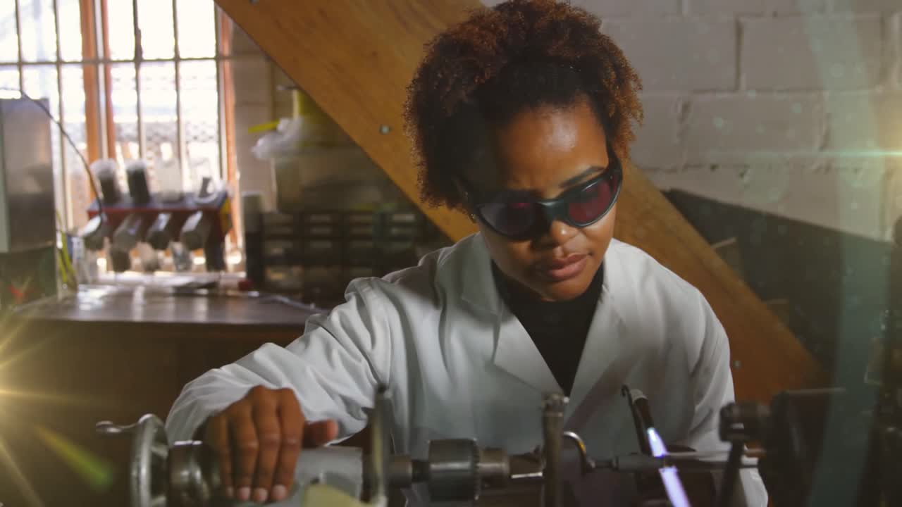 Animazione di luce luminosa su donna afroamericana che lavora in officina