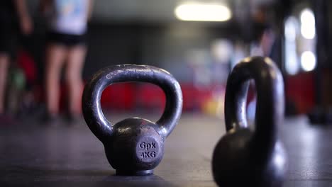 Dos-Pesas-De-Cuatro-Kilogramos-Con-Asas-En-El-Suelo-De-Un-Gimnasio-Interior-De-Crossfit