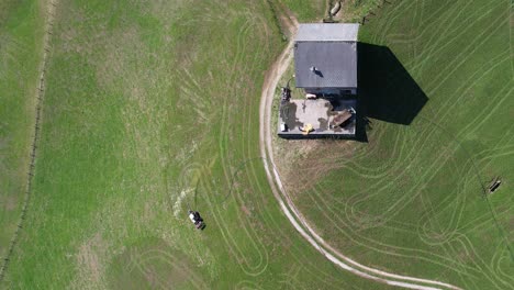 Granjero-Suizo-Rociando-Fertilizante-En-Su-Campo-En-Las-Colinas,-Vista-Aérea