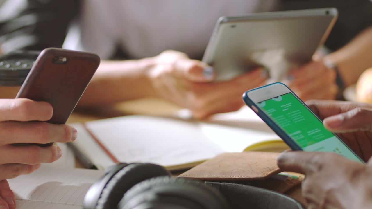 personas que colaboran en dispositivos móviles en una reunión