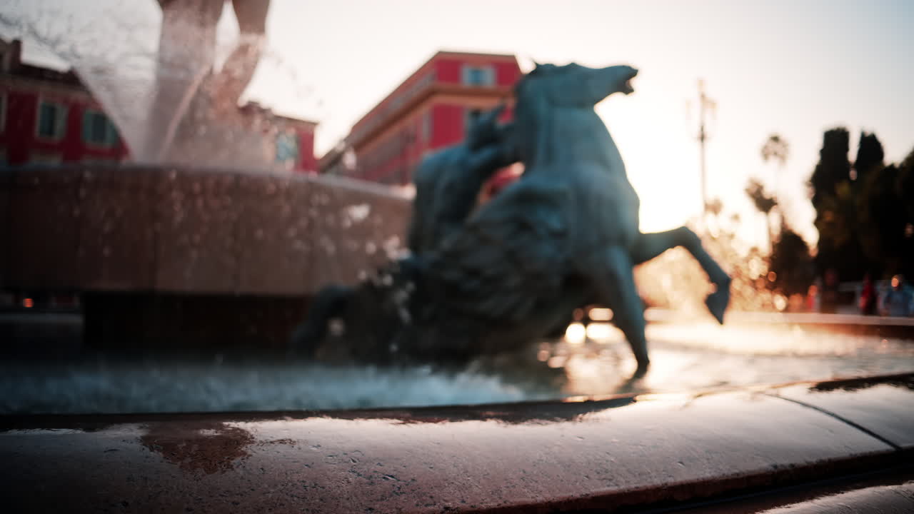 Nice, France - October 8, 2024: Blurry view of the Fontaine du Soleil in Place Massena at sunset