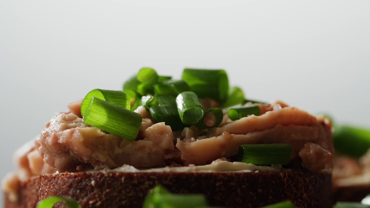 Smoked cod liver in oil in open tin can with fresh greens on wooden table. Seafoods delicacy. High quality 4k footage