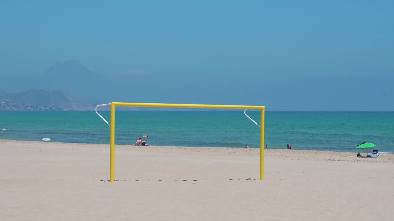 A yellow football goal, also known as football gate, is seen at the beach on the shore of the Mediterranean sea in Alicante, Spain.
