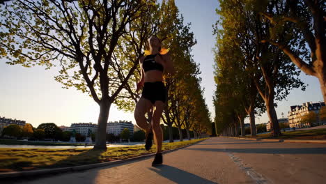 woman running through a city park at sunset