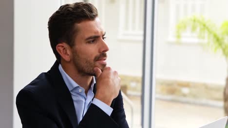 thoughtful businessman working on laptop at desk 4k