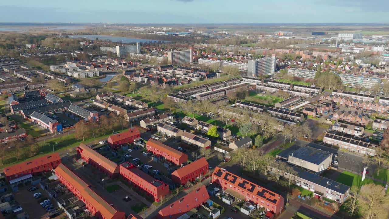 Dronebeelden die vooruit bewegen over Hoogezand, Nederland, in de winter. Luchtfoto met een koud winterlandschap, een woonwijk en gedempte daglichtomstandigheden in een Nederlandse stad