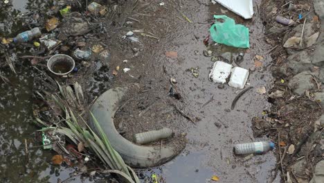 agua sucia dentro de un pequeño canal con mucha basura
