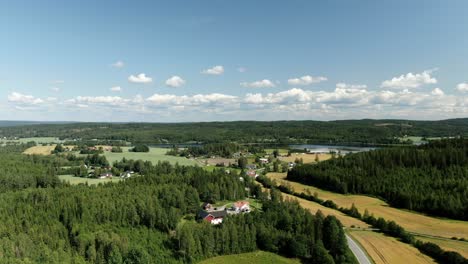 Vista-Aérea-Panorámica-Lenta-Del-Campo-Con-Montañas-Y-Lago-Al-Fondo