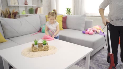 the cute little girl helps her mother with the cleaning.