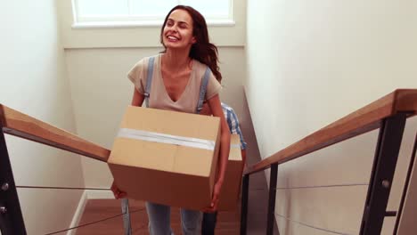 happy couple carrying cardboard