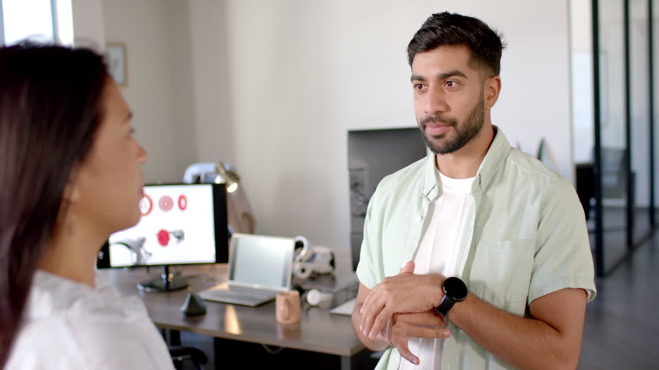 Discussing robotics project, colleagues in modern office with computer and gadgets