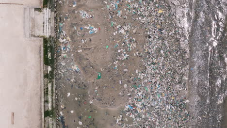 garbage washed up on seaside on beach in bangkok thailand, aerial top down