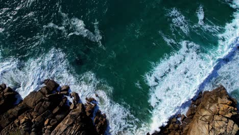 Dramatische-Kornische-Wellen-Entlang-Der-Felsigen-Küste-Von-Einer-Luftdrohne,-Die-Von-Oben-Nach-Unten-Aufsteigt,-Cornwall,-England,-Vereinigtes-Königreich