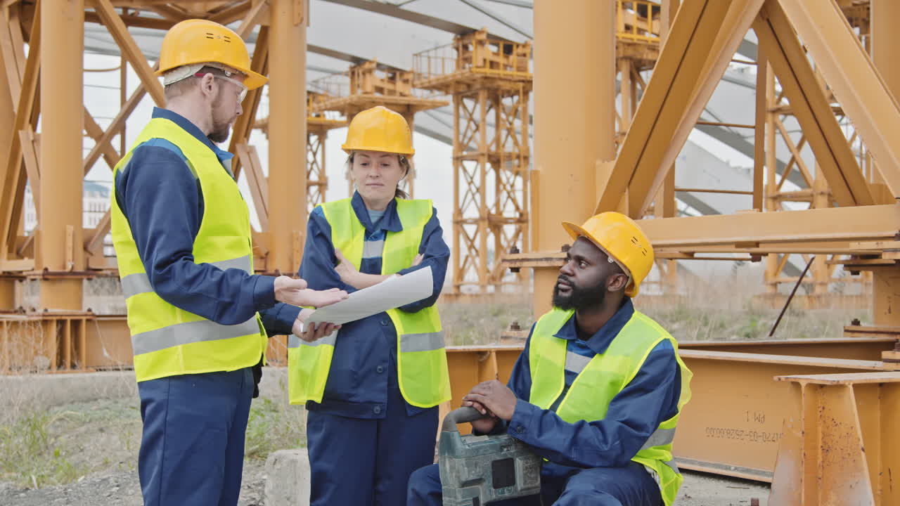 Engenheiro dando instruções para trabalhadores em canteiro de obras