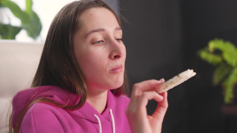 Mujer-Joven-Feliz-Sentada-En-El-Escritorio-Y-Comiendo-Galletas-De-Arroz-1