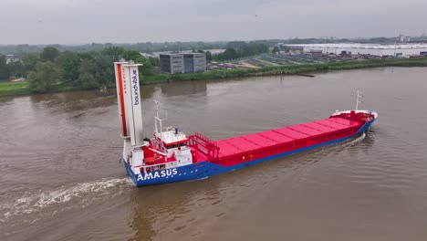 cargo ship with flettner rotors for wind propulsion on a river