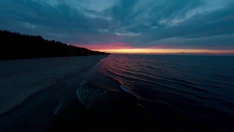 FPV-Drohne-Fliegt-Bei-Sonnenuntergang-Nah-über-Den-Wellen-Der-Ostsee-In-Polen