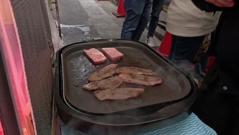 kobe beef slices being grilled on hot plate.