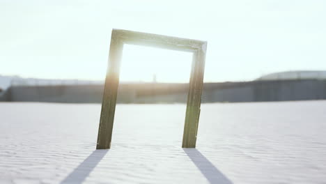 Empty-wooden-picture-frame-on-the-beach-sand