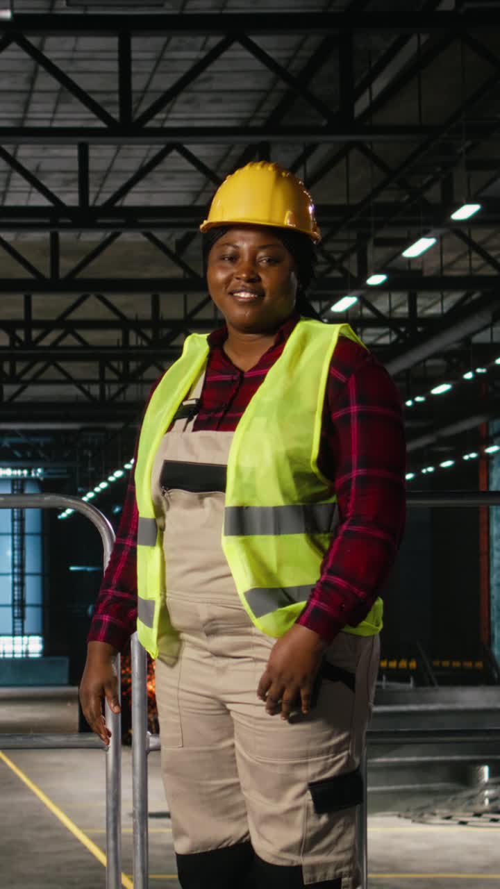 Vídeo Vertical. Retrato de mulher negra trabalhando em fábrica de engenharia de indústria pesada.