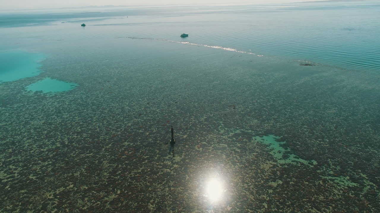Aerial Shot rotating around Abu Nuhas Coral Reef Island in The Red Sea of Egypt in the North beside Hurghada with the drone circulating in a rotation around a light house