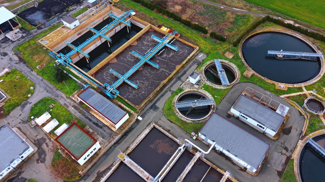 High angle view of aeration tanks in treatment plant. Detailed aerial shot of rectangular aeration basins and circular clarifiers with moving bridges for water cleaning