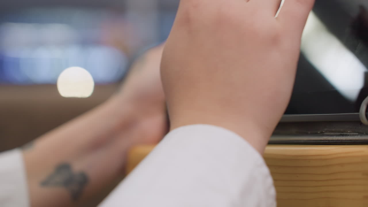 hands of person engaged in online conversation with client using tablet as soft bokeh lights glow in blurred background creating relaxed digital work ambiance in modern indoor environment