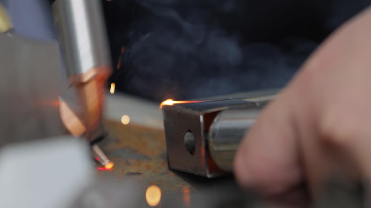 Laser welding machine with hand hold gun. Laser welding is shown in close-up.