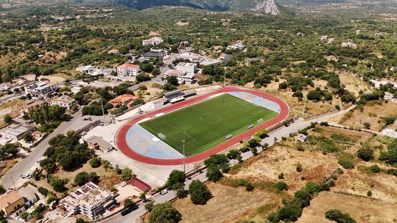Aerial view of Dorgali football pitch surrounded by scenic Sardegna landscape