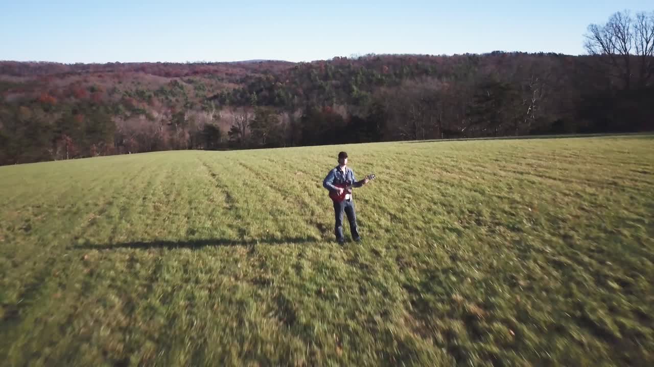 Man playing guitar in a field